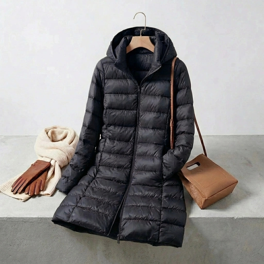 Kovera black long puffer coat with slim fit silhouette and removable hood, styled with a scarf, gloves, and handbag.