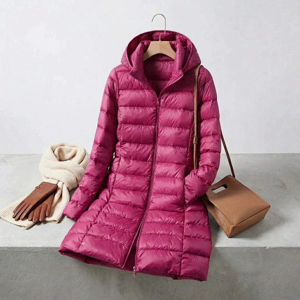 Kovera long puffer coat in deep magenta with slim fit silhouette and removable hood, styled with scarf, gloves, and handbag.