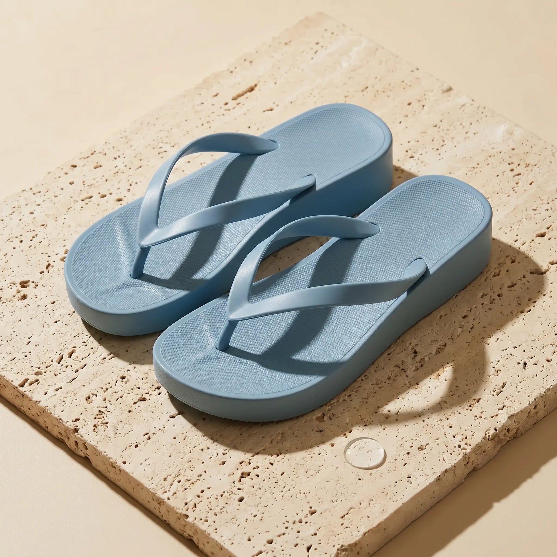 Kozwen Ocean Mist Blue platform wedge sandals, showcasing honeycomb textured footbeds and smooth PVC Y-straps, styled on a beige textured block.