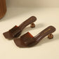 Brown square-toe slip-on mule sandals with a transparent geometric block heel and a single semi-transparent strap.