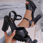 Kylos black PU leather platform high heel sandals with fish-mouth peep-toe and ankle strap, shown on a foot styled with jeans against a reflective, disco-themed background.