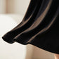 Close-up of the flowing A-line hem of the Kynso black premium modal slip dress, showcasing the soft micro-knit texture and elegant drape in natural light.