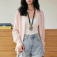 Female model wearing Kynzor Delicate Lychee Pink Lightweight Tencel Blouse, styled open over a white tank top. This lifestyle shot highlights the semi-sheer fabric, relaxed fit, and long sleeves in an indoor setting.