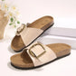 Pair of Kyraan women's beige comfort cork slides with antique brass buckle strap and open-toe design, displayed on a clean studio surface.
