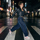 Kyro architectural curved leg jeans in midnight indigo, side view of model walking on a city street showing the voluminous balloon fit.