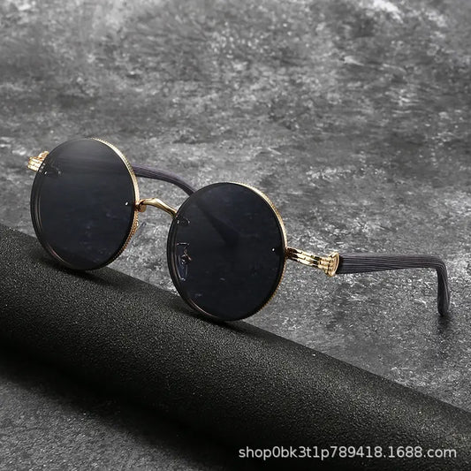 Gold round metal frame sunglasses featuring dark grey gradient lenses and unique wood-grain textured temples, shown in a three-quarter view on a dark studio background.
