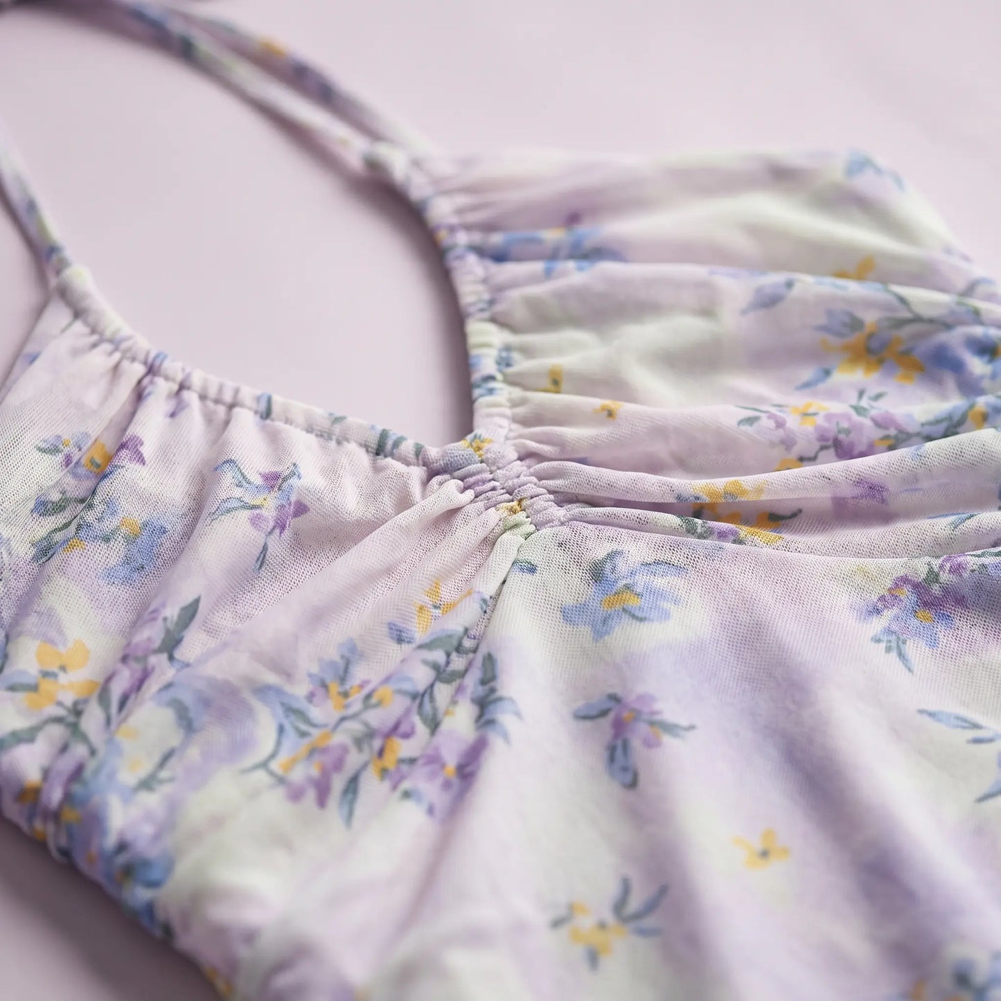 Close-up of the Zevrak Romantic Floral Mesh Ruched Maxi Dress, showcasing the delicate lilac mesh fabric with a watercolor floral print in yellow and blue, and the intricate horizontal ruching on the bodice.