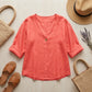 Luvana sunset orange linen blend blouse in a flat-lay arrangement with a straw hat and bag, showcasing the V-neck and half-sleeve design.