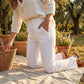 Luvana linen blend trousers in desert sand with an elastic drawstring waist, worn by a woman in a relaxed outdoor setting.
