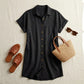 Luvara black linen-blend shirt dress with tortoiseshell buttons, styled in a flat-lay with woven sandals, straw bag, and sunglasses.