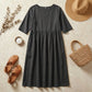 Luvia cotton linen midi dress in charcoal grey, styled as a flat-lay with a straw hat, sandals, and handbag on a neutral surface.