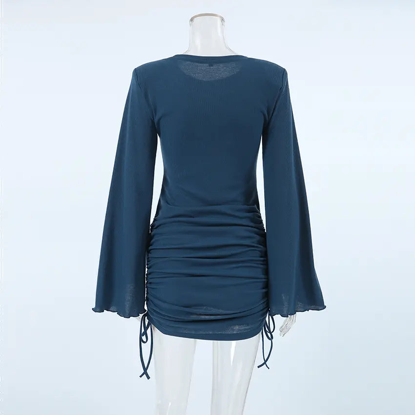 Back view of a dark blue ribbed knit mini dress featuring dramatic long bell sleeves and adjustable side ruching detail on the skirt.