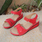 Red Lyraia comfort wedge sandals for women, featuring a peep-toe front with diamond perforations, adjustable hook-and-loop straps, and contrasting white stitching on a textured sole.