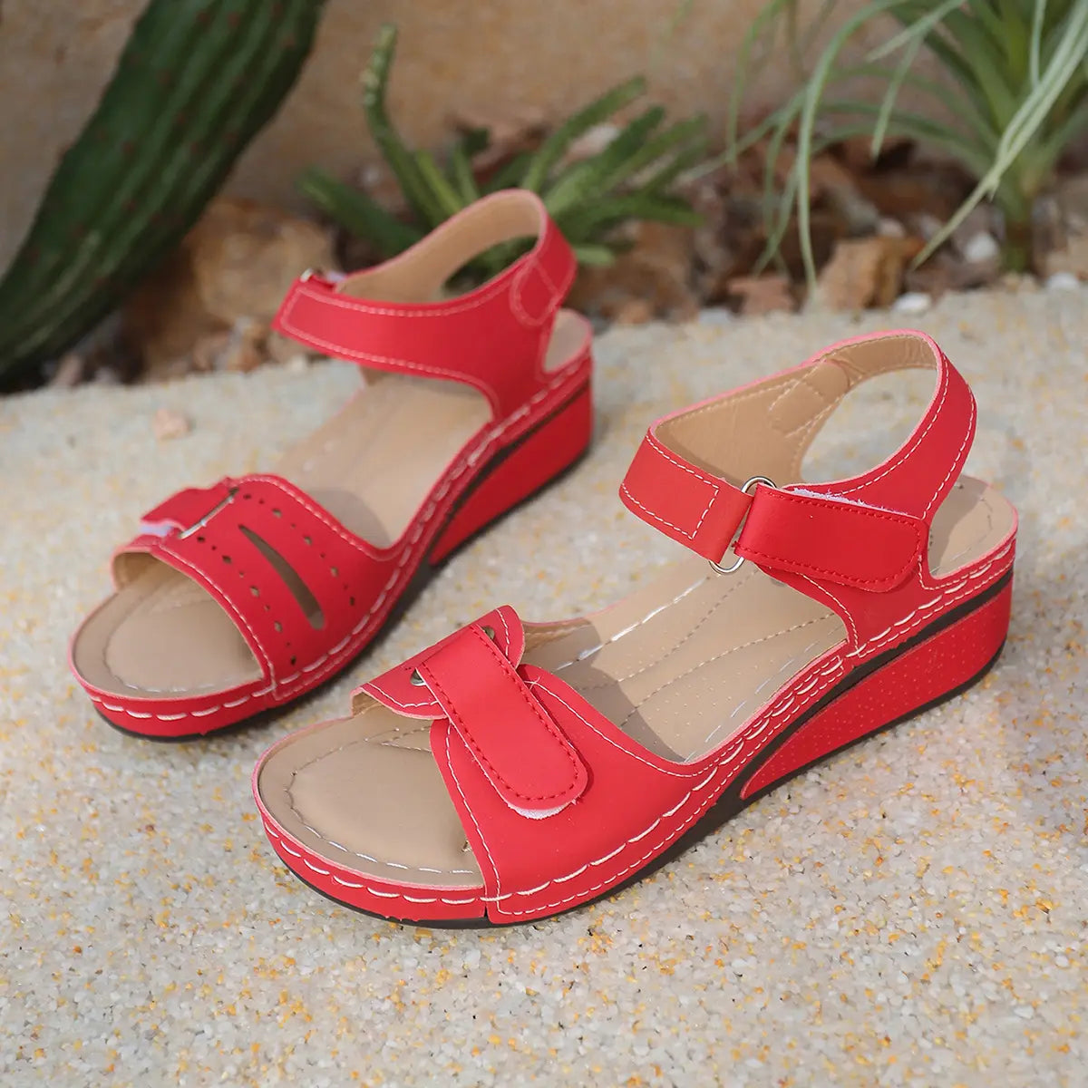 Red Lyraia comfort wedge sandals for women, featuring a peep-toe front with diamond perforations, adjustable hook-and-loop straps, and contrasting white stitching on a textured sole.