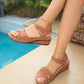 Woman wearing tan Lyraia comfort wedge sandals with peep-toe, adjustable straps, and white contrast stitching, by a pool.