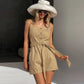Woman wearing a Mavrix belted wide-leg romper in oatmeal beige, styled with a wide-brimmed hat and sunglasses.