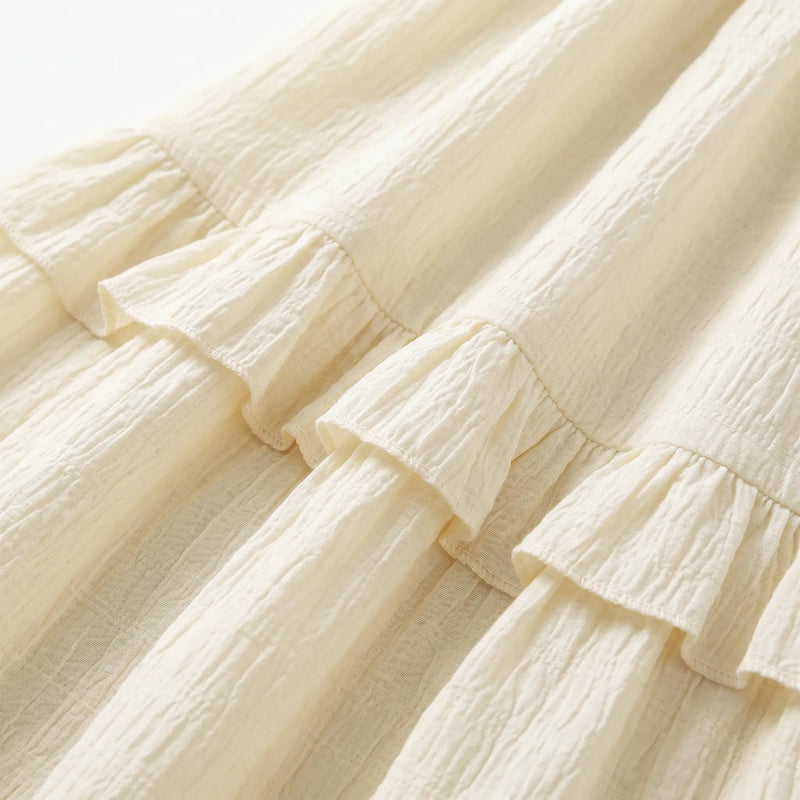 Close-up of the Zyrak creamy pale yellow Romantic Textured Ruffle Maxi Dress fabric, highlighting the micro-crinkle woven grid and soft ruffled seam detail.