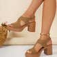 Model's legs wearing warm tan suede-finish platform sandals with a V-cut forefoot strap and a thick, ribbed block heel, styled with a pearl anklet on a soft, neutral background.