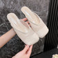 A pair of off-white breathable mesh mules with a square toe and smooth faux leather trim, held by hands against a marbled background.