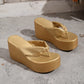 Metallic gold wedge platform flip-flops with a knotted toe strap and a textured woven-effect platform base, shown from a three-quarter angle.