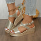 Golden metallic peep-toe wedge sandals with embossed crocodile texture and T-strap, styled with distressed denim jeans on a model's feet.