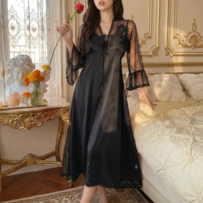 Sylven Midnight Black satin nightgown, floral lace V-neck, sheer polka dot bell sleeves, worn by model in romantic bedroom.