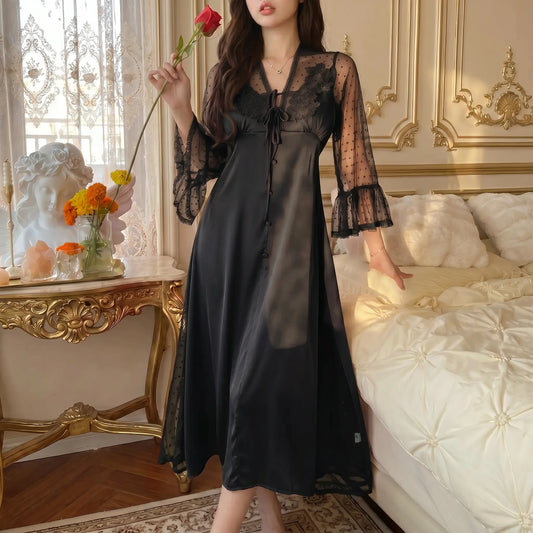 Sylven Midnight Black satin nightgown, floral lace V-neck, sheer polka dot bell sleeves, worn by model in romantic bedroom.