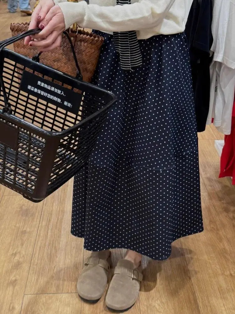 Kozira Midnight Polka Dot A-Line Midi Skirt, highlighting its flowing silhouette and classic pattern with a distinct mid-skirt seam, worn casually.