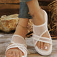 White mesh wedge sandals with criss-cross straps and open toe, worn by a person with anklets, showcasing comfortable summer style.