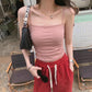 Model wearing a Soft Rose ruched camisole top with spaghetti straps, showcasing its slim fit and textured front, in an outdoor lifestyle setting.