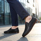 Mokasso men's comfort driving loafer in black vegan leather worn outdoors, showing the flexible rubber sole bending naturally as the model steps.