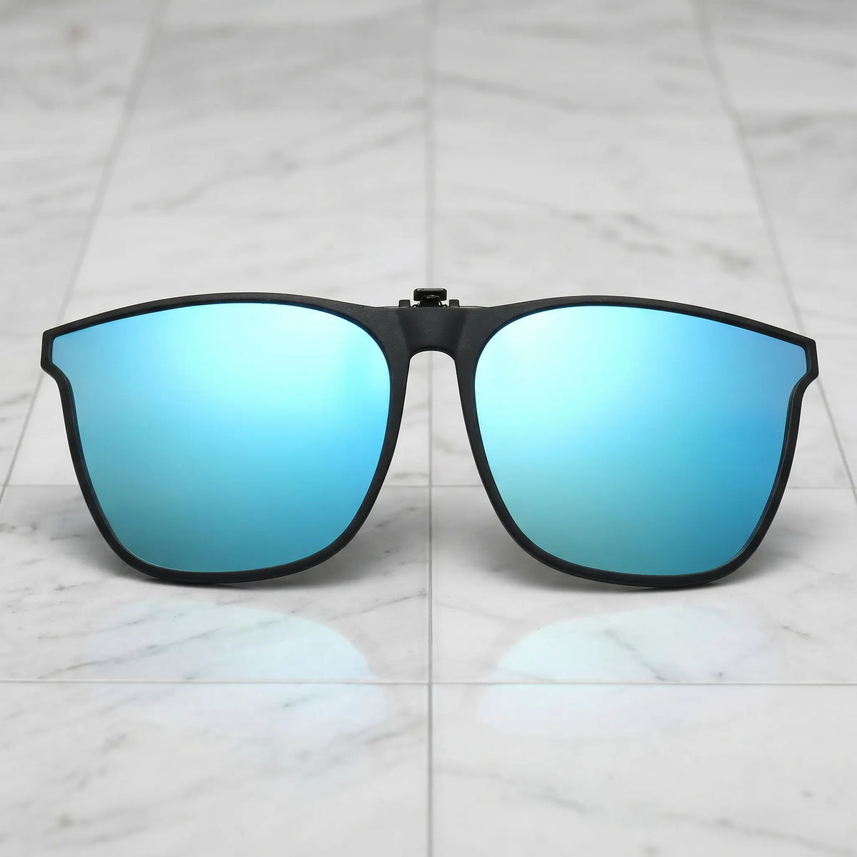 Nalani matte black square clip-on sunglasses with blue mirrored polarized lenses, presented from a front view on a white background.