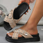 Natural beige platform slide sandals adorned with silver studs and featuring an ornate silver buckle, shown on a model's foot in a lifestyle setting with a soft-focus background.