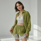 Olive green linen-blend relaxed fit shirt and wide-leg shorts set with delicate white lace trim, worn by a model with pearl necklace and brown handbag.