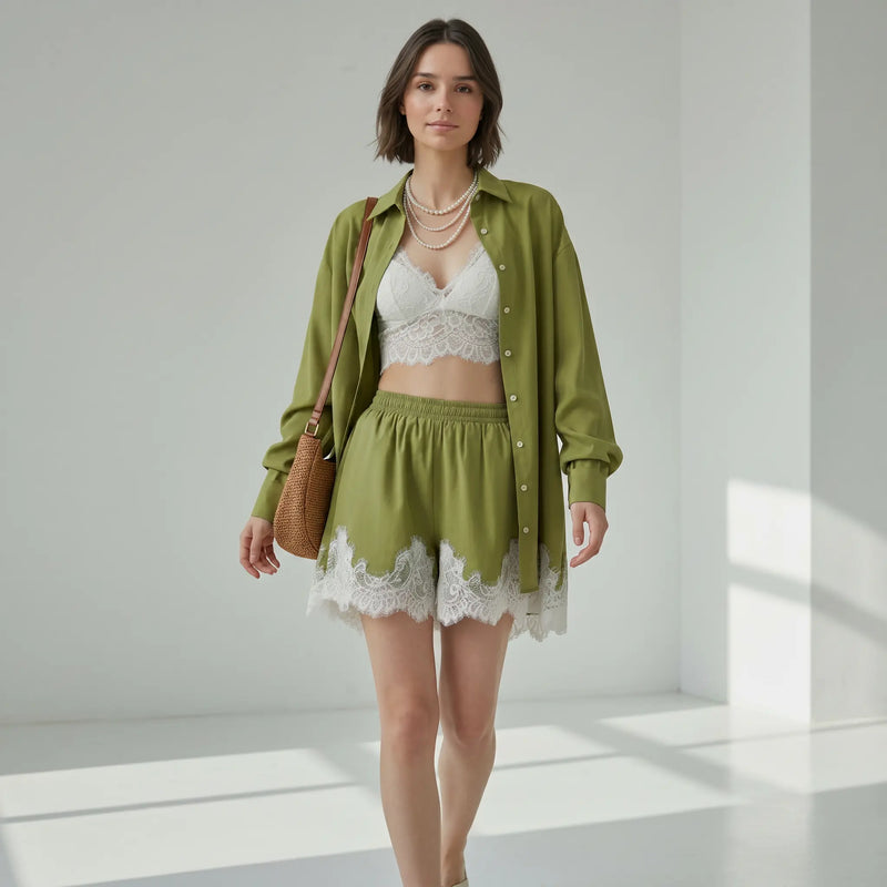 Model wearing an olive green linen-blend relaxed-fit shirt and wide-leg shorts adorned with delicate white floral lace trim, styled with a white bralette and pearl necklace.