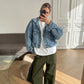 Woman wearing high-rise, olive green wide-leg utility trousers with front patch pockets, styled casually with a denim jacket and white t-shirt in a modern interior.