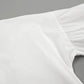 Close-up of the pale pink linen-blend fabric for a women's set, showcasing the textured weave and gathered sleeve construction with adjustable tie cuffs.