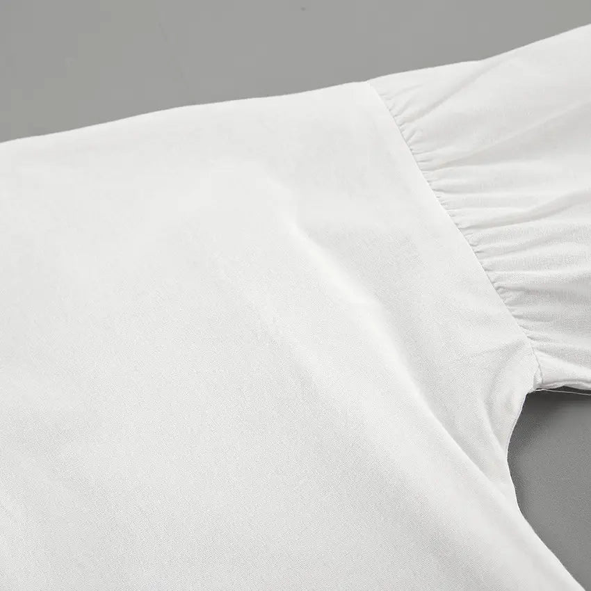 Close-up of the pale pink linen-blend fabric for a women's set, showcasing the textured weave and gathered sleeve construction with adjustable tie cuffs.