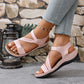 Light pink women's comfort sport sandals with criss-cross elastic straps and beige accents, worn with light-wash jeans on a model's feet.