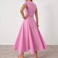 Elegant pink cotton two-piece set, featuring a cropped cap-sleeve top and a voluminous A-line midi skirt with a full button-front closure, shown from the back.