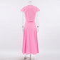 Back view of the Zylia pink cotton two-piece set featuring a cropped top with cap sleeves and a high-waisted, flowing A-line midi skirt.