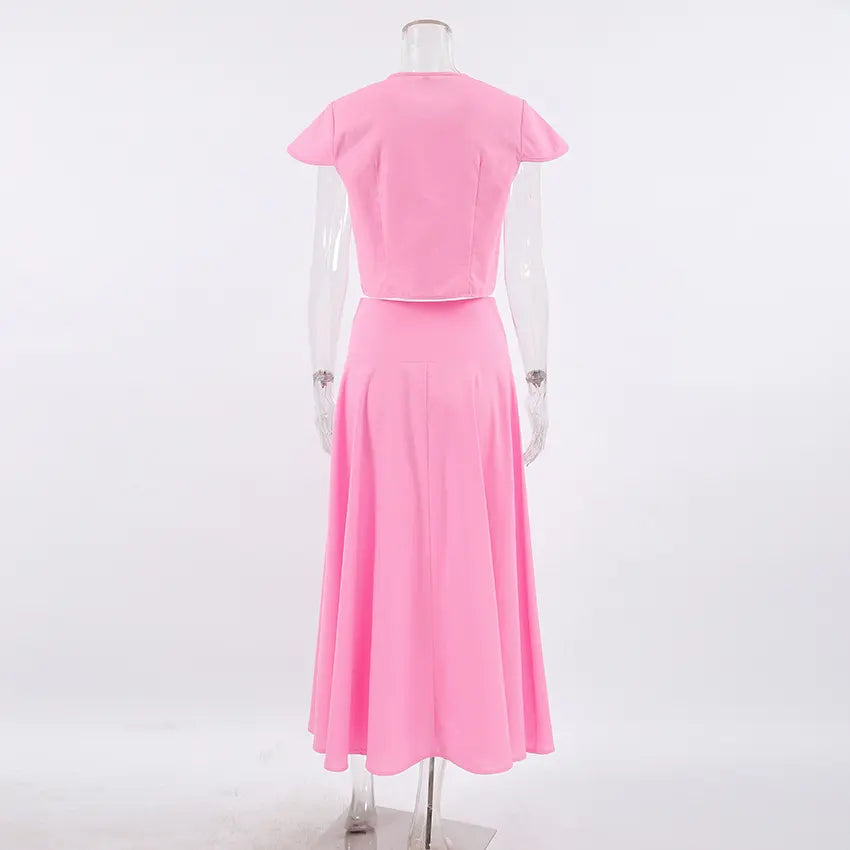 Back view of the Zylia pink cotton two-piece set featuring a cropped top with cap sleeves and a high-waisted, flowing A-line midi skirt.