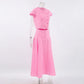 Vibrant pink cotton two-piece set on a mannequin, featuring a cropped button-up top with cap sleeves and a high-waisted, A-line midi skirt with a full button-down front, shown from a side angle.