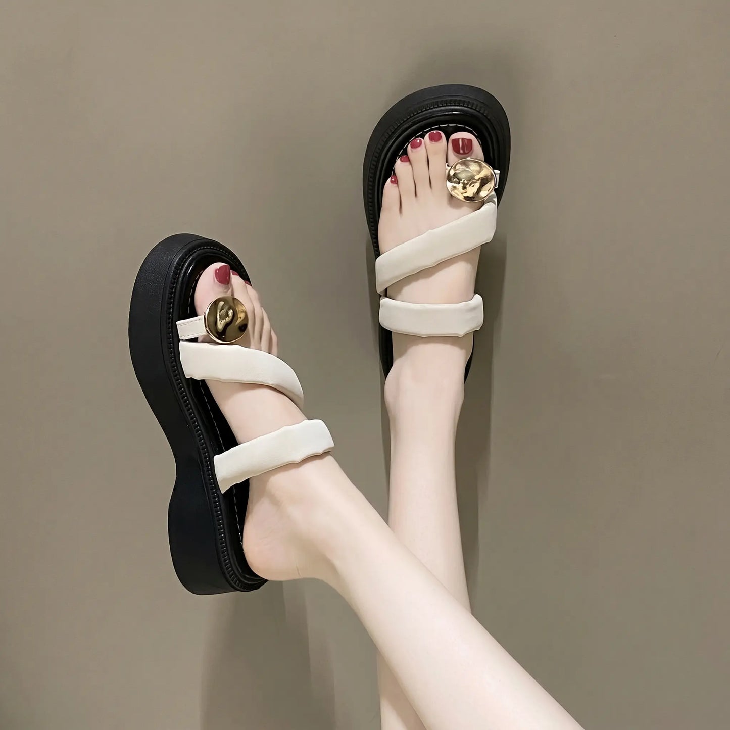 Cream white platform thong sandals with plush velvet-feel straps and a polished gold buckle, shown on feet from a three-quarter angle against a neutral studio background.
