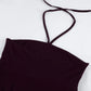 Close-up of a deep plum ribbed halter neck crop top, showcasing thin adjustable straps tied at the nape of the neck and a form-fitting silhouette. Studio shot on a white background.