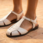 Pure White Kevroz woven vegan leather fisherman sandals on feet, highlighting the T-strap, square toe, and gold-tone buckle.