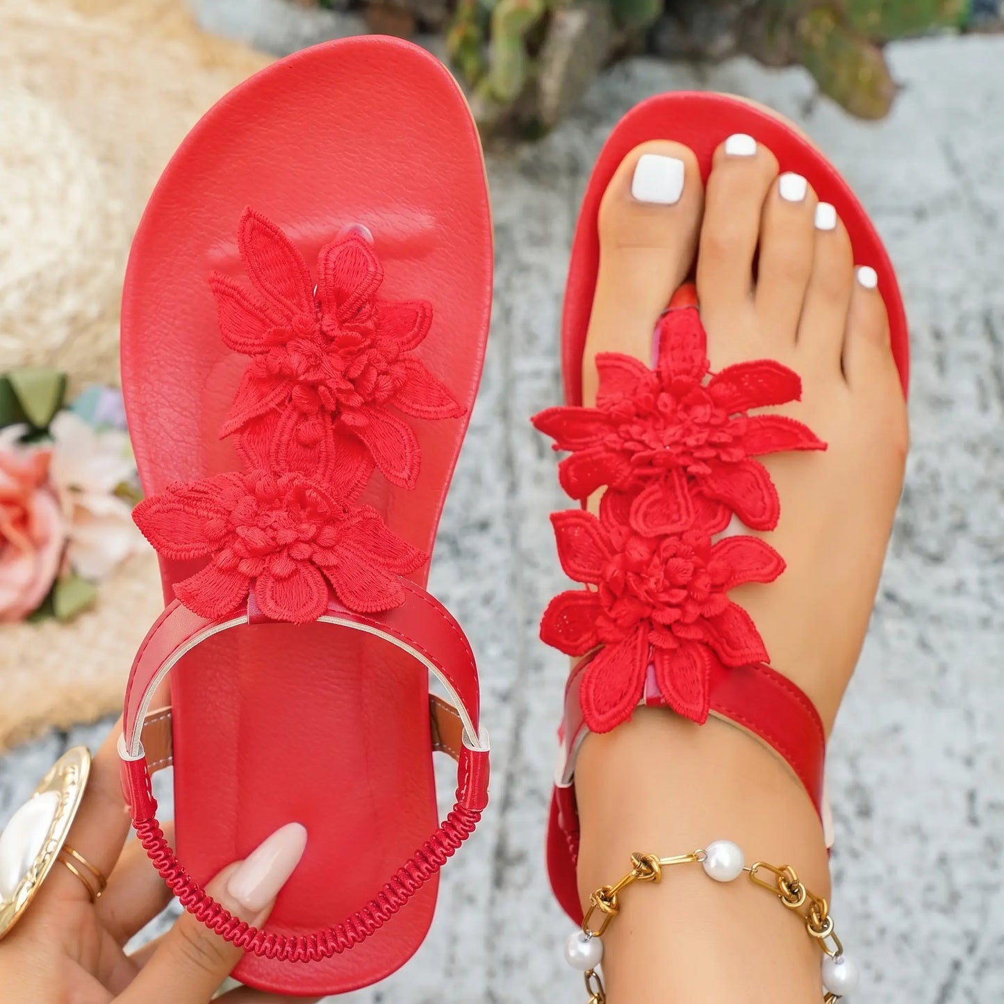 Bohemian red flat sandals for women, featuring layered fabric floral appliqués and a comfortable elasticated slingback strap, shown on a foot with white-toe nails.