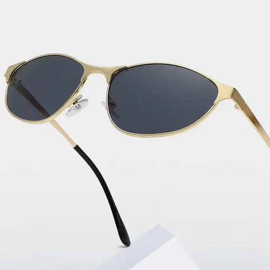 Rhodan gold metal cat-eye sunglasses with dark grey lenses and black temple tips, shown at a three-quarter angle on a studio background.