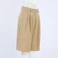 Rhyza Women's Tailored Bermuda Shorts in Khaki, featuring a high waist, wide leg, front pleats, and cuffed hem, shown from a three-quarter view on a white background.
