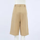 Back view of Rhyza tailored high-waist Bermuda shorts in khaki, featuring a wide leg, cuffed hem, and clean-finished waistband.